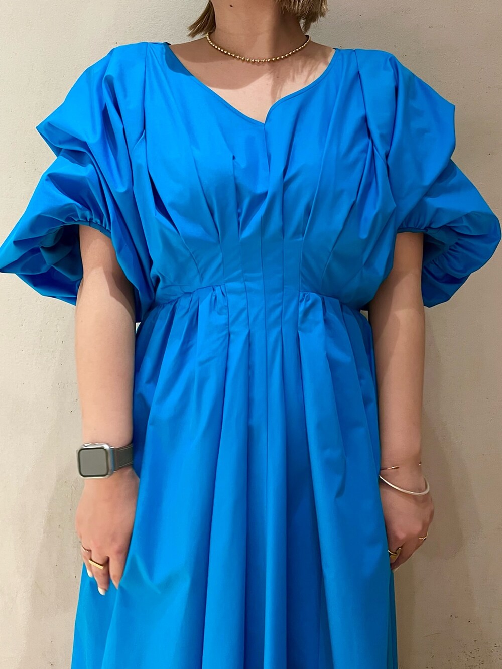 ブルー系のワンピース、ホワイト系のサンダル、ゴールド系のネックレスを着用したレディースの冬コーディネートの5枚目の写真