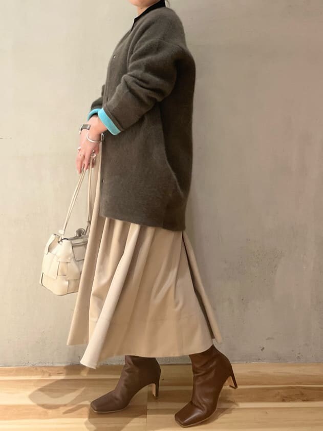 ベージュ系のジャンパースカート、ブラウン系のブーツ、ベージュ系のその他アウターを着用したレディースの秋コーディネートの2枚目の写真