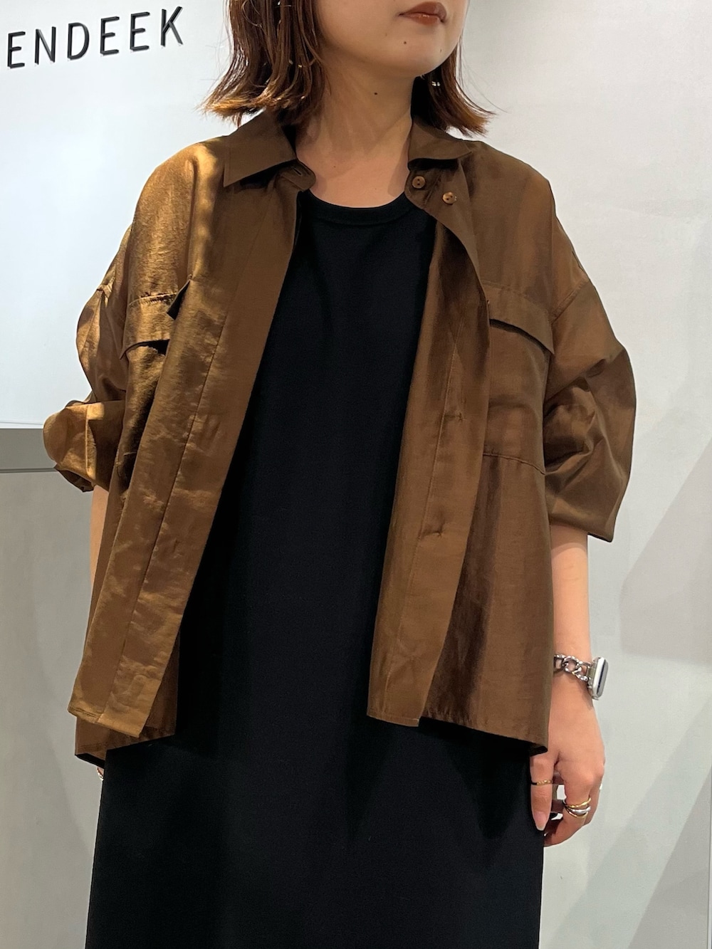 ブラウン系のシャツ/ブラウス、ブラック系のワンピース、ブラウン系のサンダルを着用したレディースの夏コーディネートの5枚目の写真
