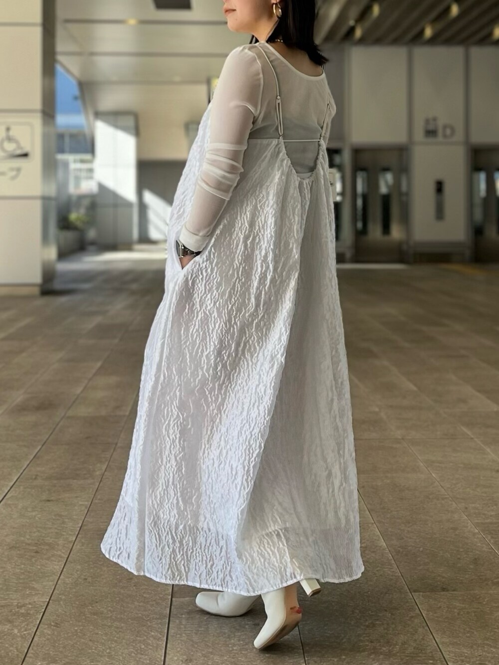 ホワイト系のTシャツ/カットソー、ホワイト系のワンピース、ホワイト系のブーツを着用したレディースの冬コーディネートの2枚目の写真