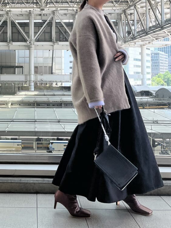 ブラック系のジャンパースカート、ホワイト系のショルダーバッグ、ベージュ系のシャツ/ブラウスを着用したレディースの夏コーディネートの4枚目の写真