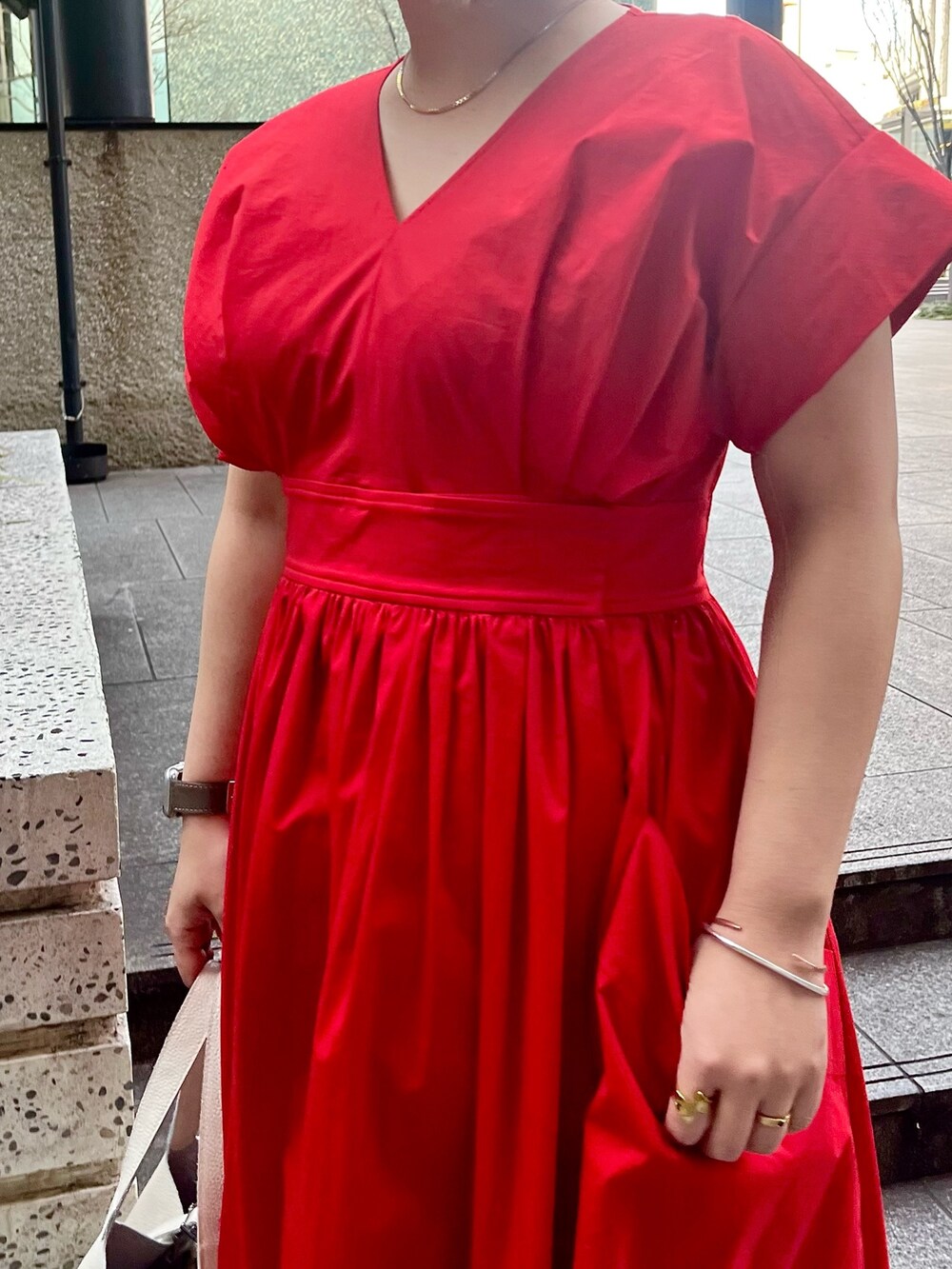 レッド系のワンピース、ホワイト系のハンドバッグ、ホワイト系のサンダルを着用したレディースの冬コーディネートの5枚目の写真