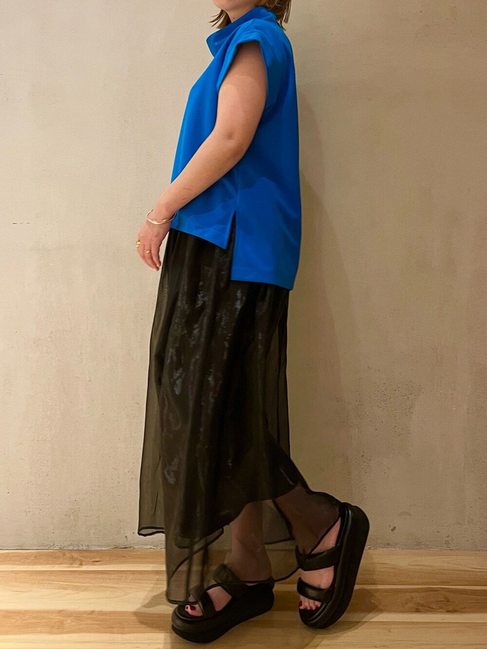 ブルー系のTシャツ/カットソー、ブラック系のスカート、ブラック系のサンダルを着用したレディースの冬コーディネートの2枚目の写真