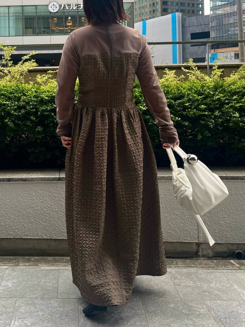 パープル系のカーディガン/ボレロ、ホワイト系のハンドバッグ、ベージュ系のワンピースを着用したレディースの夏コーディネートの8枚目の写真