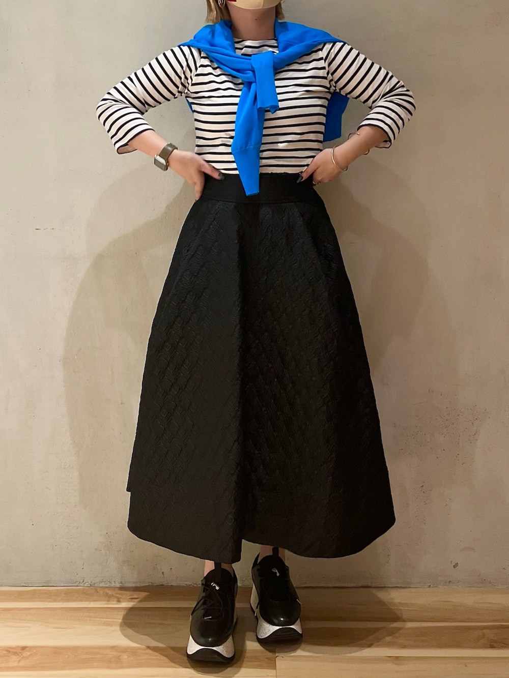 ブルー系のカーディガン/ボレロ、ブラック系のスカート、ブラック系のスニーカーを着用したレディースの春コーディネートの4枚目の写真