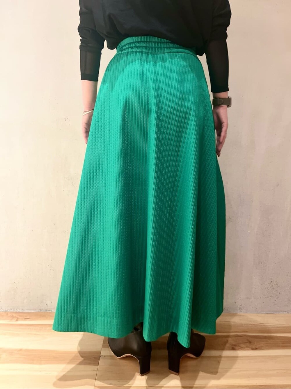 グリーン系のスカート、ブラック系のブーツ、ブラック系のTシャツ/カットソーを着用したレディースの夏コーディネートの7枚目の写真