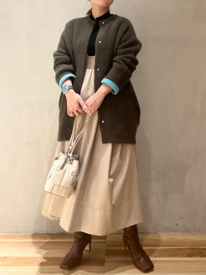 ベージュ系のジャンパースカート、ブラウン系のブーツ、ベージュ系のその他アウターを着用したレディースの秋コーディネートの5枚目の写真