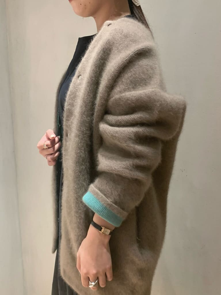 ブラック系のワンピース、ブラック系のブーツ、ベージュ系のカーディガン/ボレロを着用したレディースの秋コーディネートの4枚目の写真