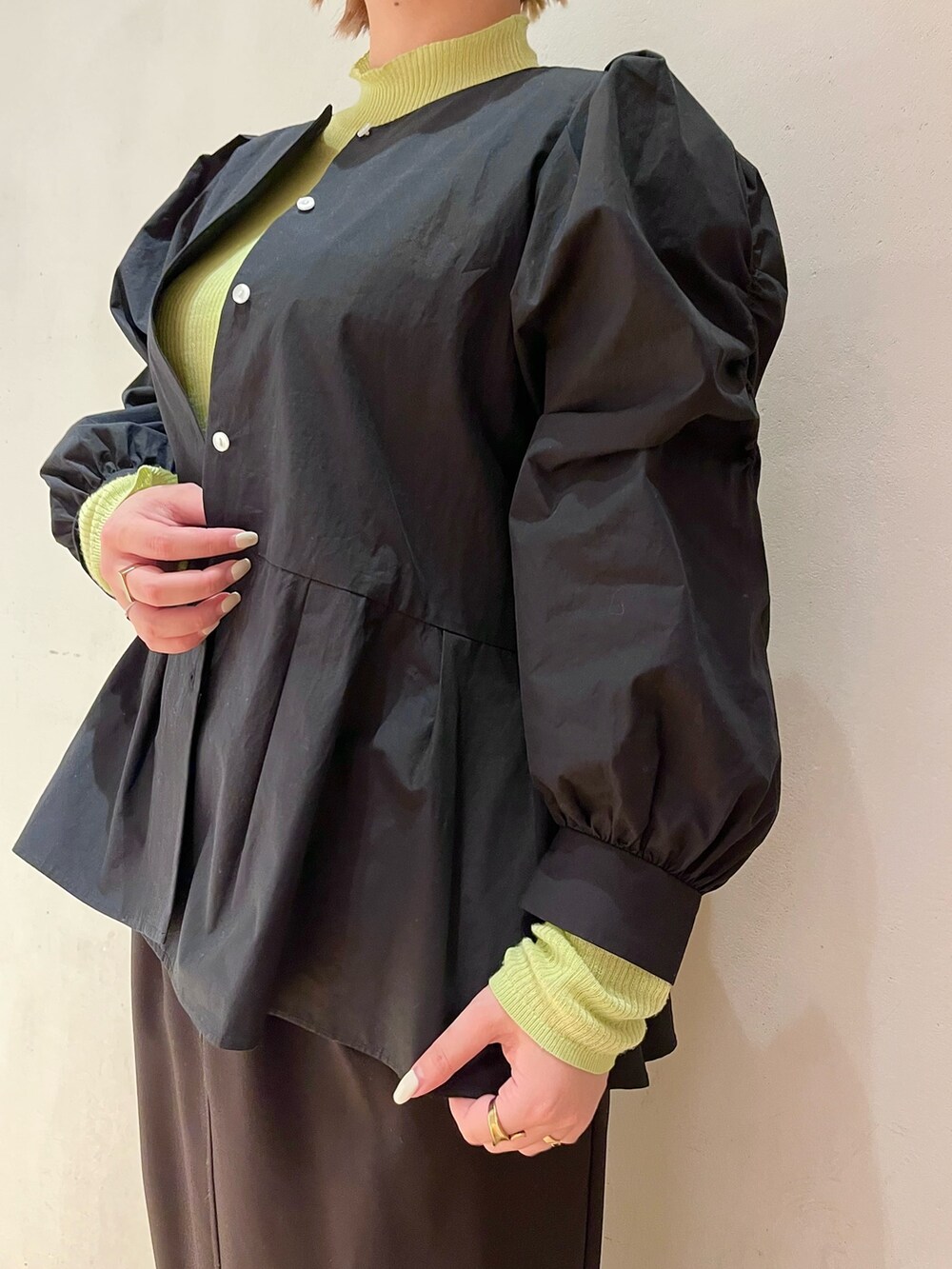 ブラック系のシャツ/ブラウス、グリーン系のニット/セーター、ブラック系のスカートを着用したレディースの冬コーディネートの6枚目の写真