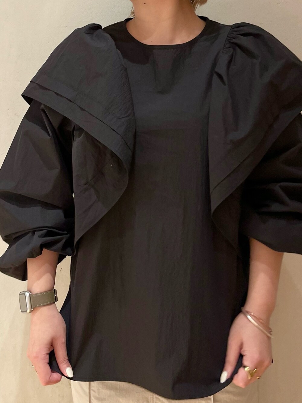 ブラック系のスニーカー、ブラック系のシャツ/ブラウス、ベージュ系のスカートを着用したレディースの冬コーディネートの4枚目の写真