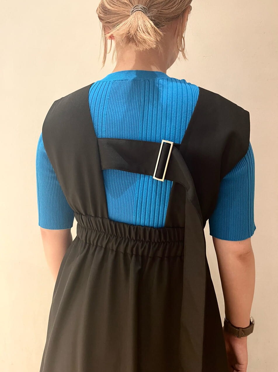 ブルー系のニット/セーター、ブラック系のジャンパースカート、ブラック系のブーツを着用したレディースの夏コーディネートの7枚目の写真