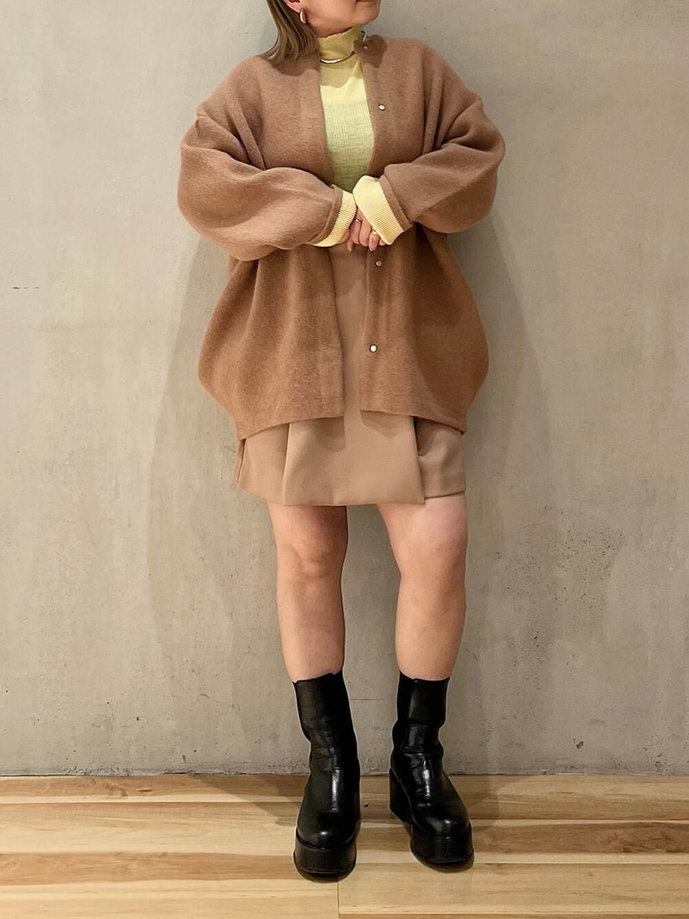 ブラウン系のノーカラージャケット、イエロー系のニット/セーター、ベージュ系のその他パンツを着用したレディースの冬コーディネートの2枚目の写真