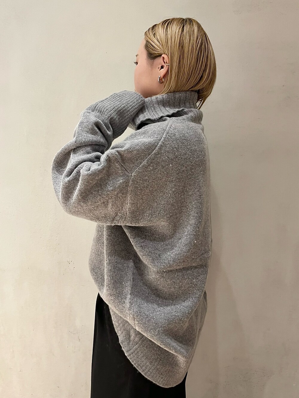 グレー系のニット/セーター、ブラック系のその他パンツ、ブラック系のブーツを着用したレディースの秋コーディネートの7枚目の写真