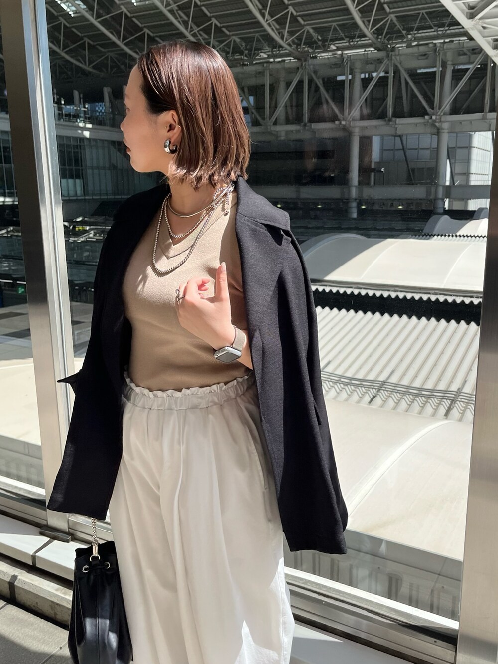 ブラック系のテーラードジャケット、ベージュ系のニット/セーター、ホワイト系のその他パンツを着用したレディースの春コーディネートの5枚目の写真