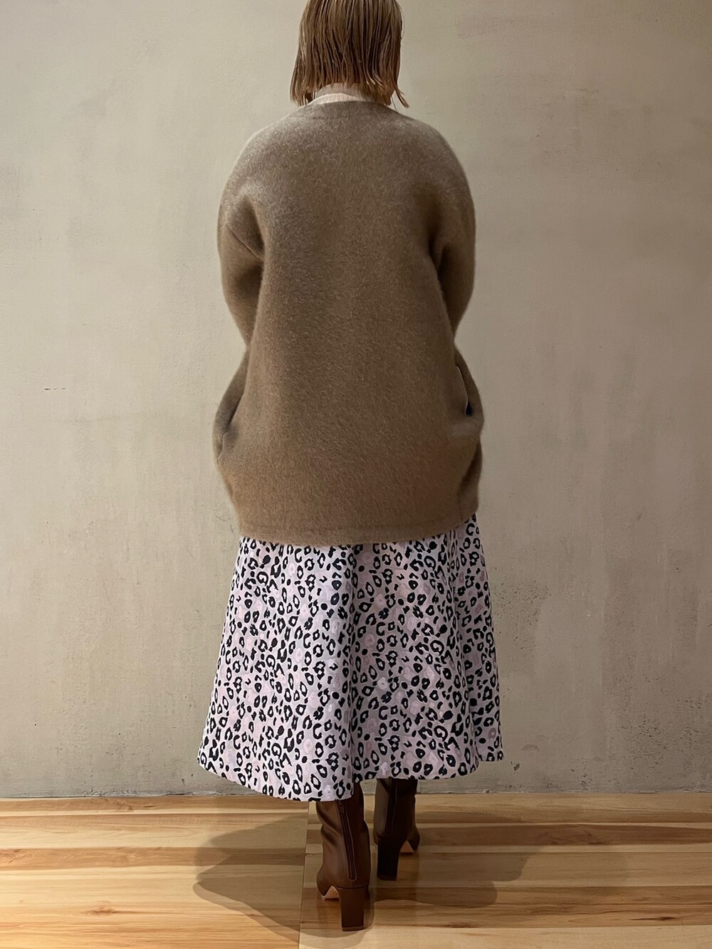 ホワイト系のニット/セーター、パープル系のスカート、ブラウン系のブーツを着用したレディースの冬コーディネートの3枚目の写真