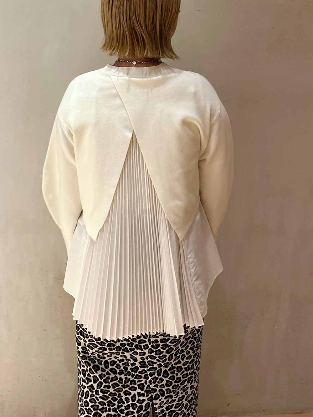 ホワイト系のスカート、ホワイト系のニット/セーター、ブラック系のショルダーバッグを着用したレディースの秋コーディネートの6枚目の写真