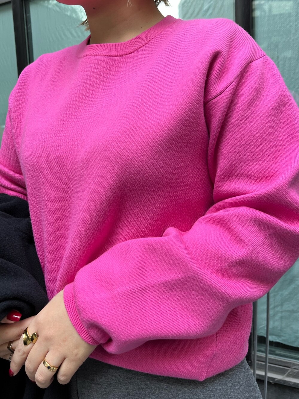 ピンク系のニット/セーター、ブラック系のチェスターコート、グレー系のスカートを着用したレディースの冬コーディネートの8枚目の写真