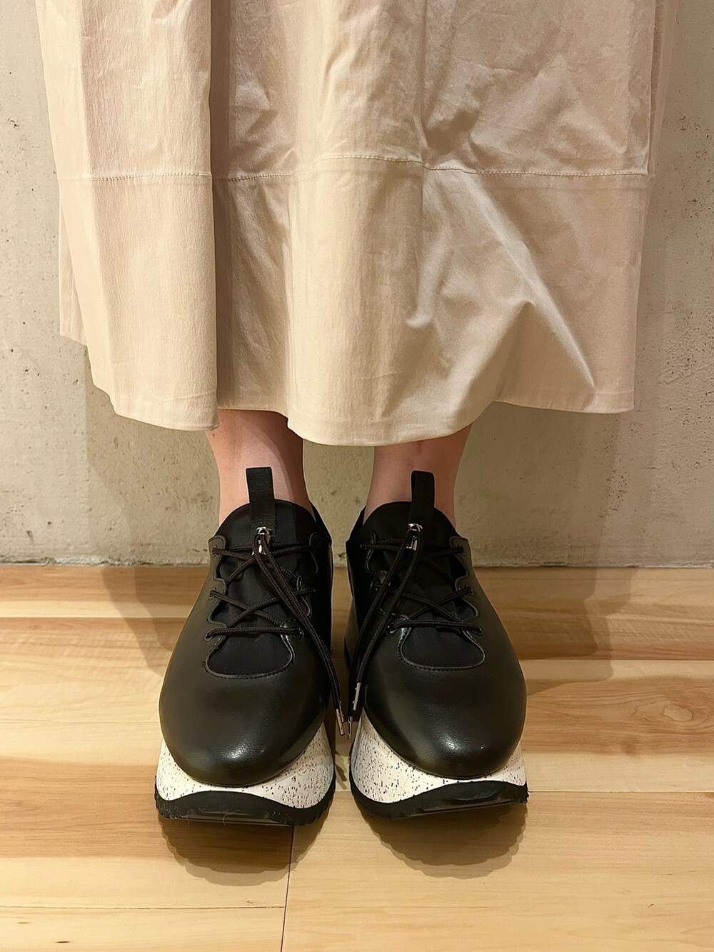 ブラック系のスニーカー、ベージュ系のワンピースを着用したレディースの春コーディネートの9枚目の写真
