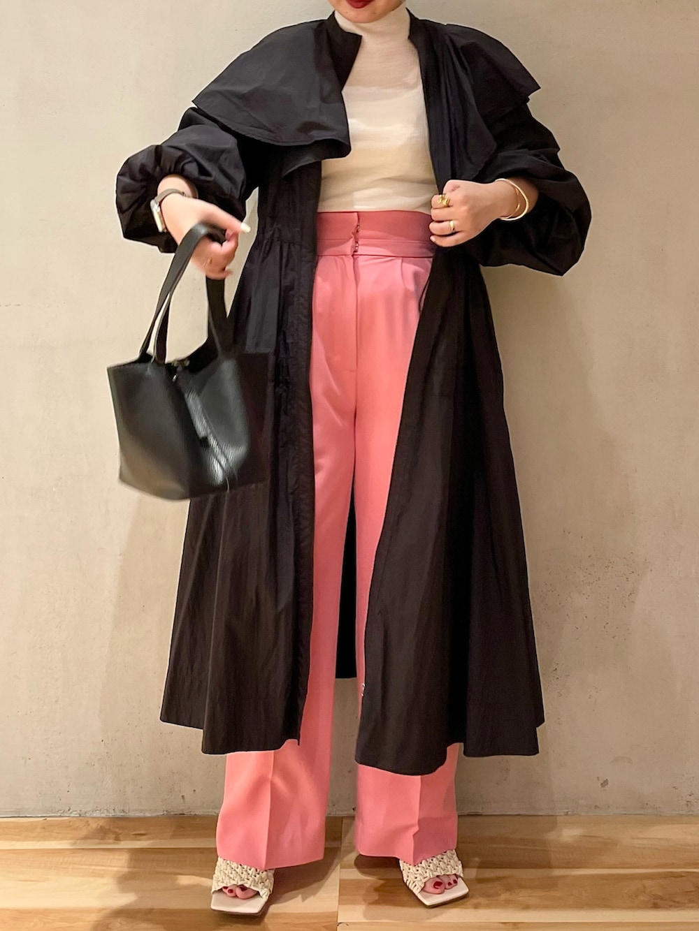 ブラック系のハンドバッグ、ホワイト系のニット/セーター、ピンク系のその他パンツを着用したレディースの冬コーディネートの4枚目の写真