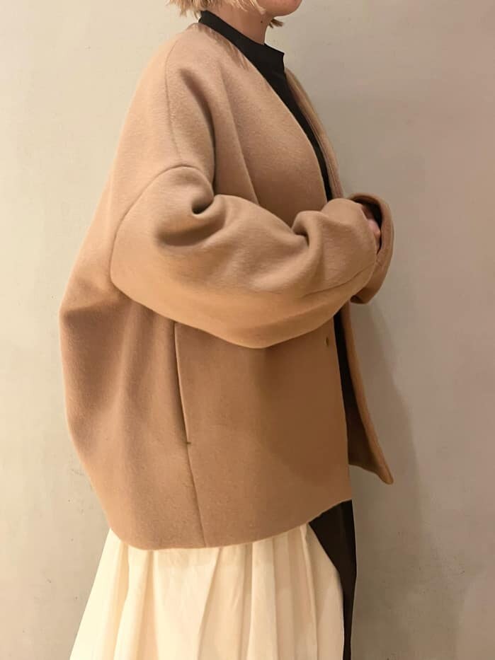 ブラウン系のブーツ、ブラック系のワンピース、イエロー系のノーカラーコートを着用したレディースの秋コーディネートの5枚目の写真