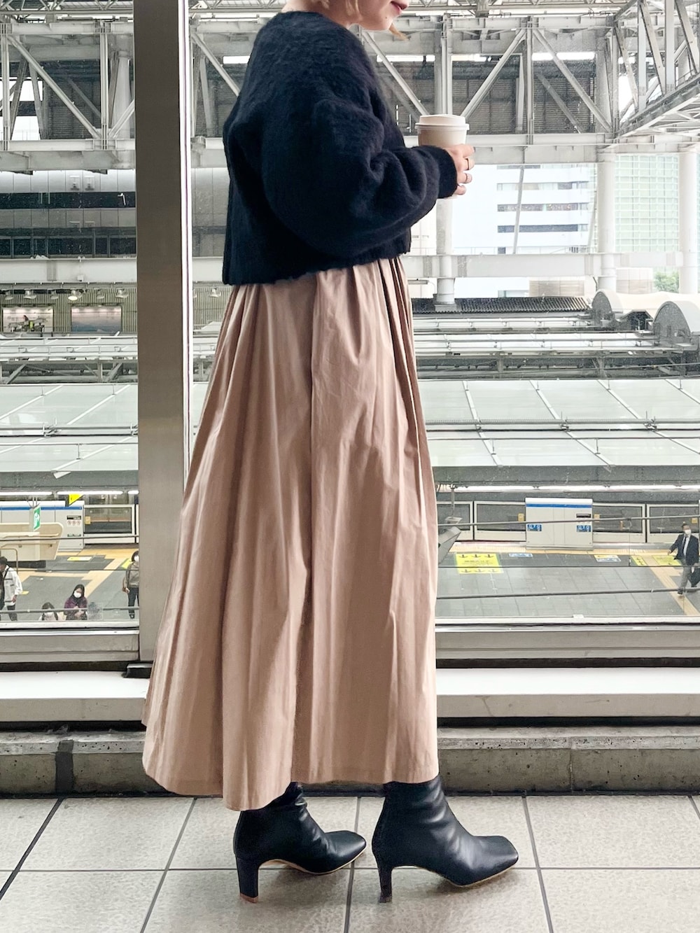 ブラック系のワンピース、ブラック系のハンドバッグ、ブラック系のブーツを着用したレディースの秋コーディネートの2枚目の写真