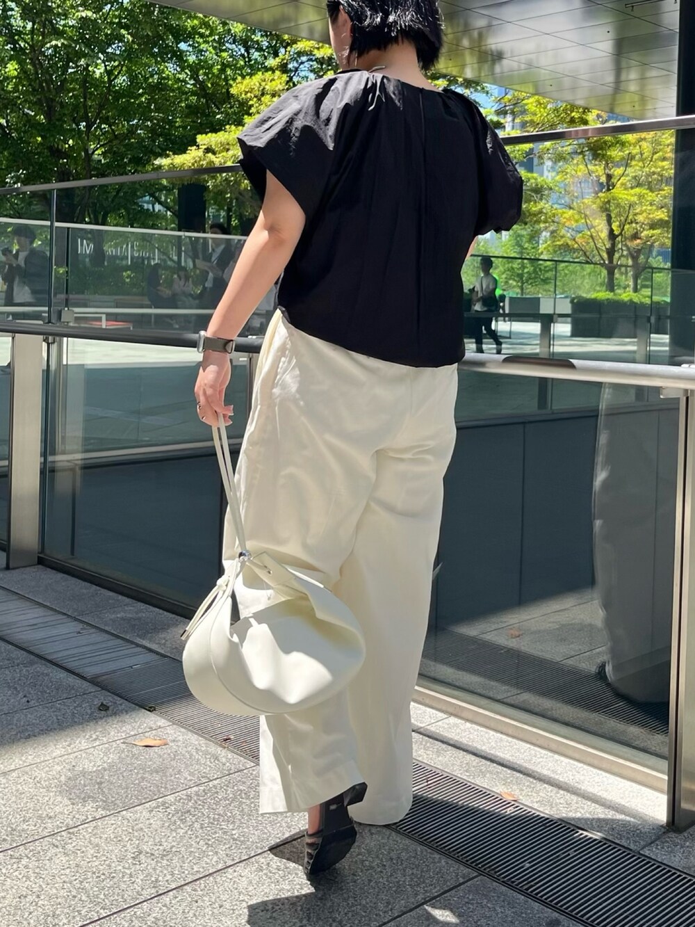 ブラック系のシャツ/ブラウス、ホワイト系のその他パンツ、ブラック系のサンダルを着用したレディースの春コーディネートの3枚目の写真