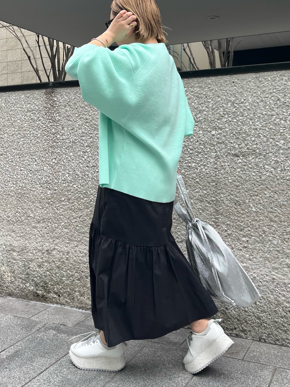 グリーン系のカーディガン/ボレロ、ブルー系のワンピース、シルバー系のトートバッグを着用したレディースの冬コーディネートの3枚目の写真