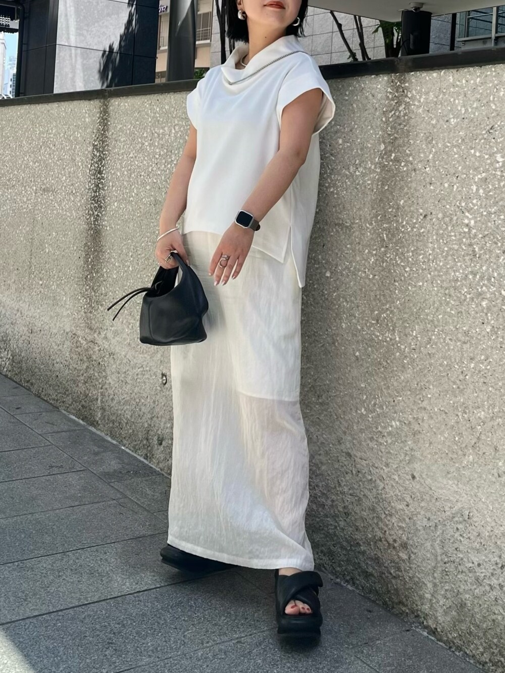 ホワイト系のTシャツ/カットソー、ホワイト系のスカート、ブラック系のサンダルを着用したレディースの春コーディネートの2枚目の写真