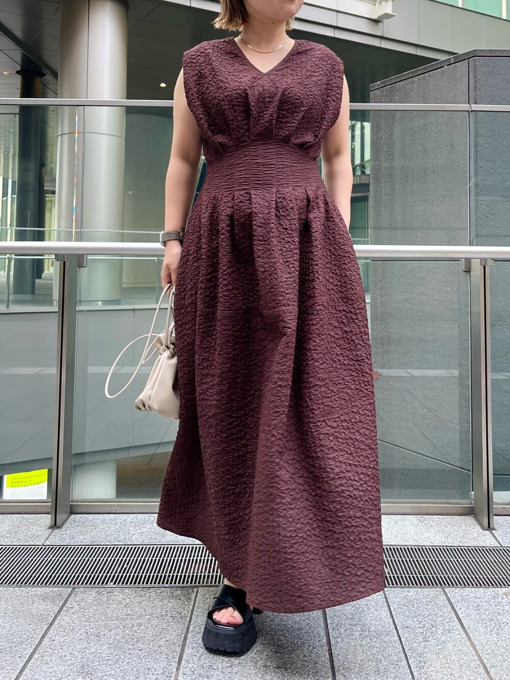 ブラック系のサンダル、ブラウン系のワンピース、シルバー系のネックレスを着用したレディースの冬コーディネートの4枚目の写真