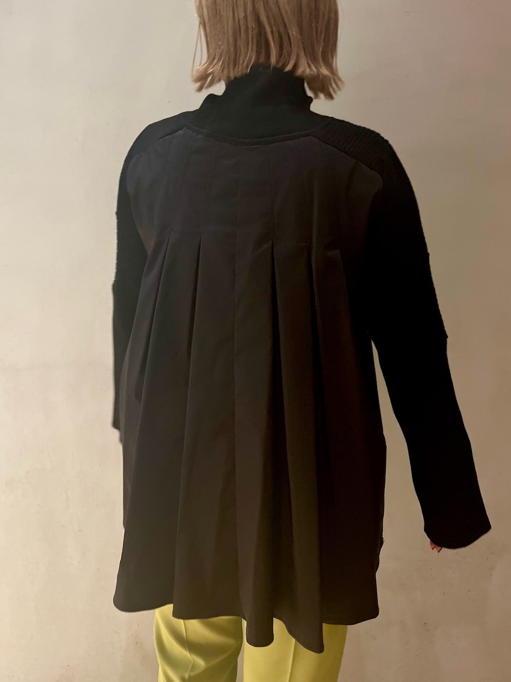 ブラック系のニット/セーター、グリーン系のその他パンツ、ホワイト系のスニーカーを着用したレディースの冬コーディネートの5枚目の写真