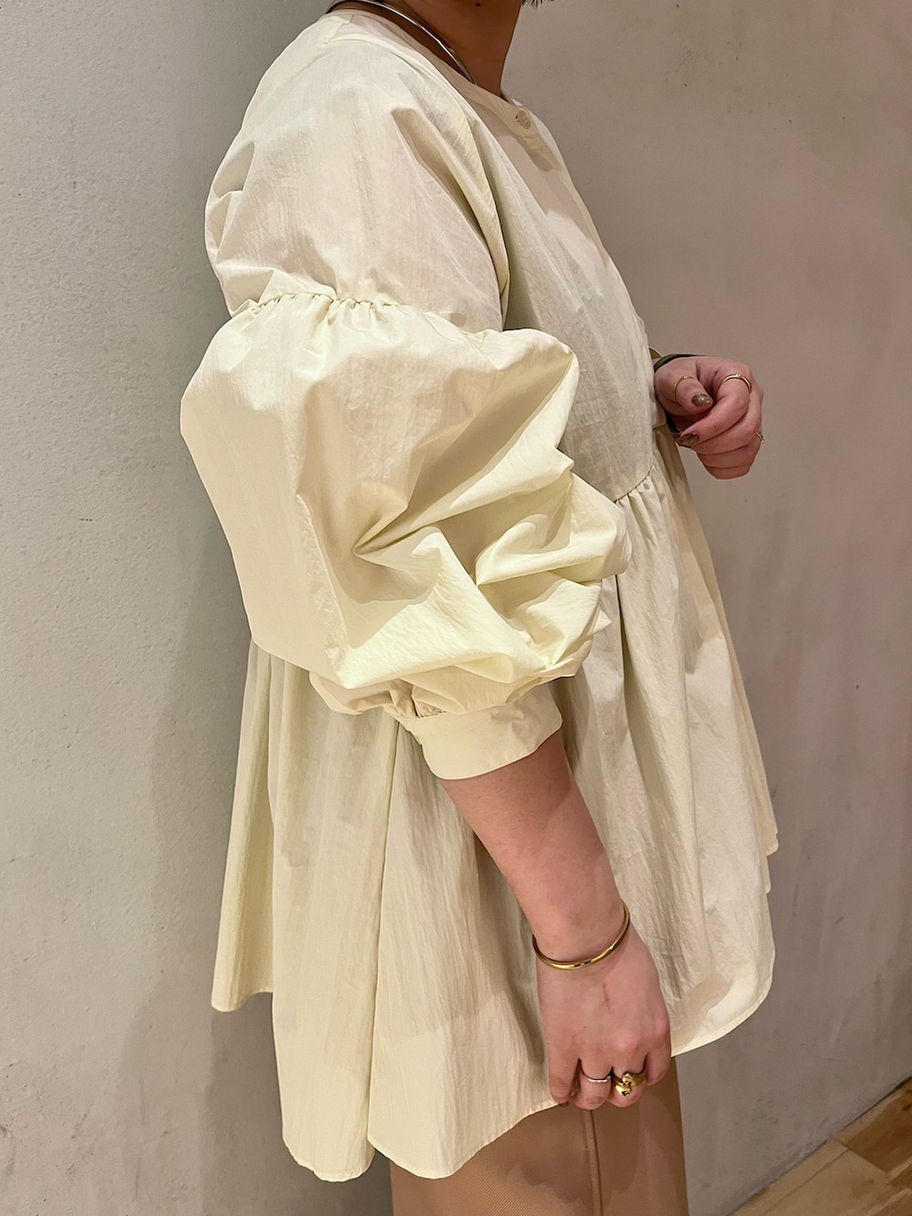 イエロー系のシャツ/ブラウス、ベージュ系のスカート、ゴールド系のパンプスを着用したレディースの春コーディネートの4枚目の写真