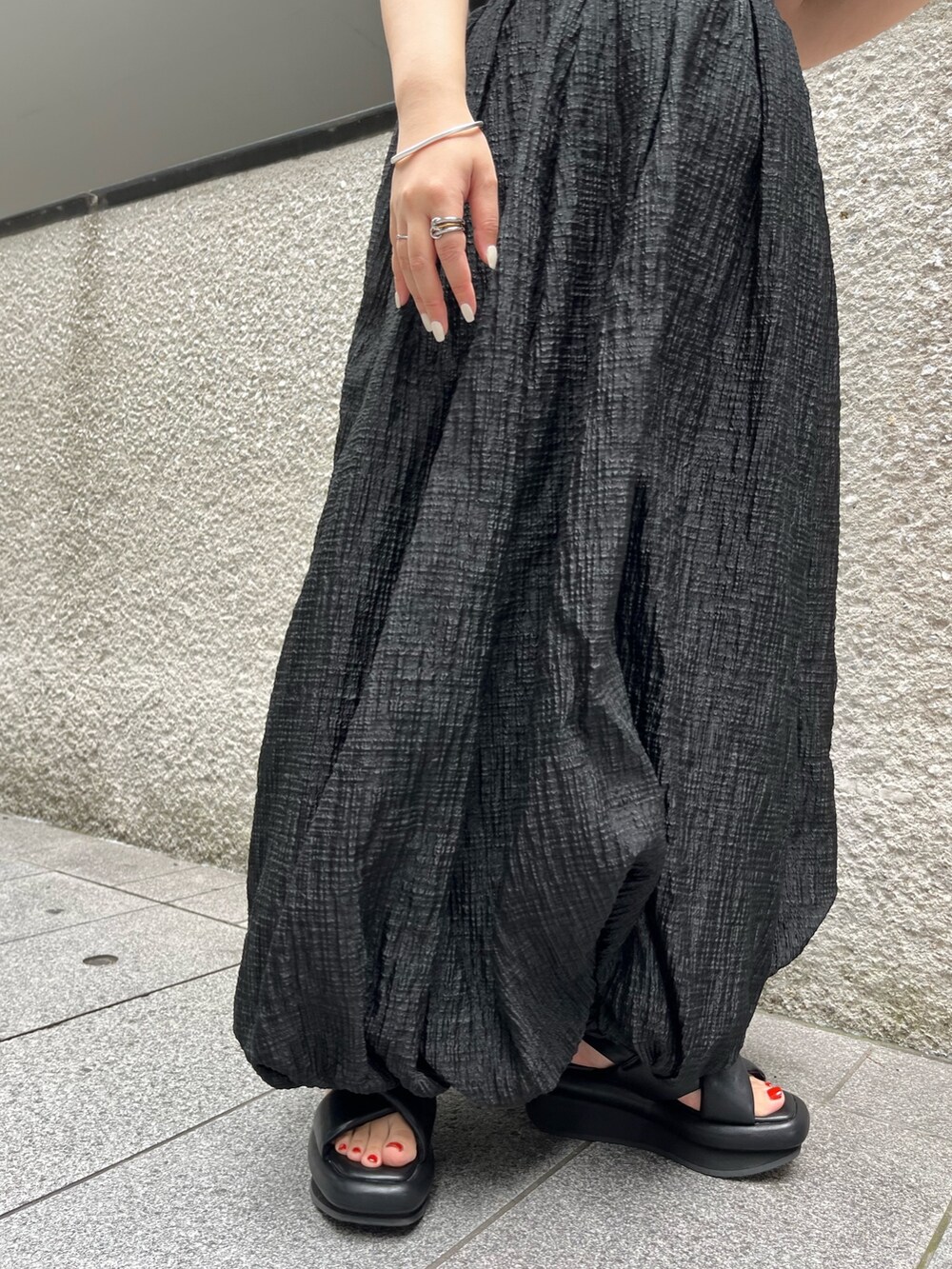 パープル系のカーディガン/ボレロ、ブラック系のサンダル、ブラック系のワンピースを着用したレディースの夏コーディネートの7枚目の写真