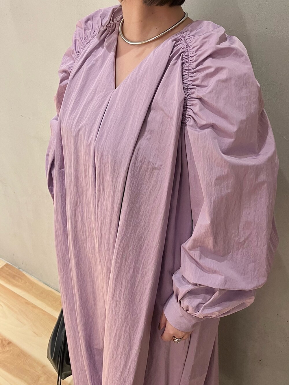 パープル系のワンピース、ブラック系のショルダーバッグを着用したレディースの春コーディネートの6枚目の写真