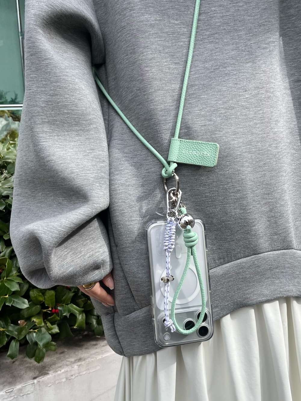 グレー系のワンピース、グリーン系のスマホケース/カバーを着用したレディースの冬コーディネートの7枚目の写真