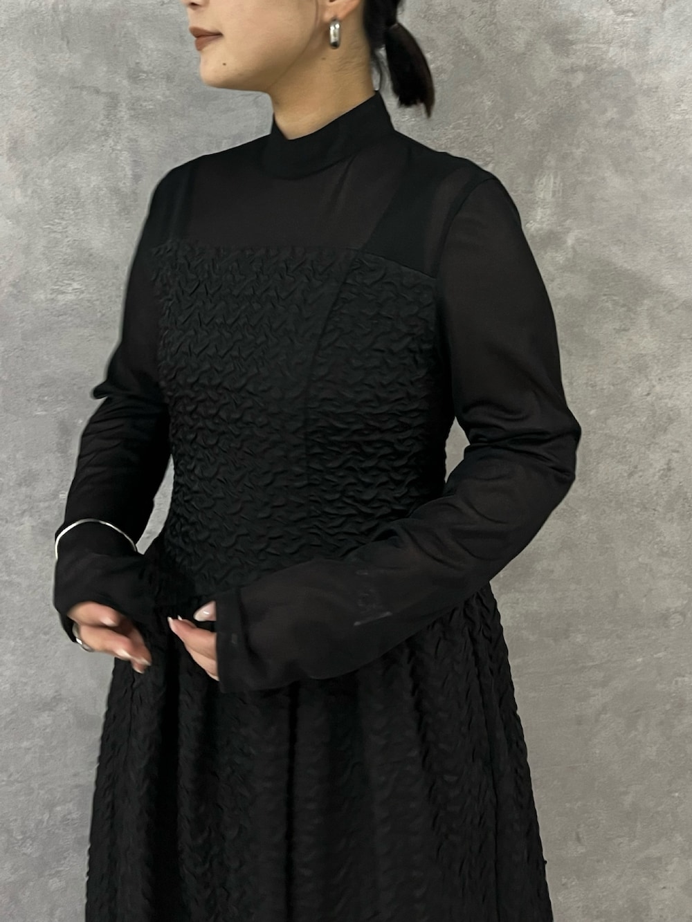 ブラック系のワンピース、ブラック系のブーツを着用したレディースの秋コーディネートの7枚目の写真