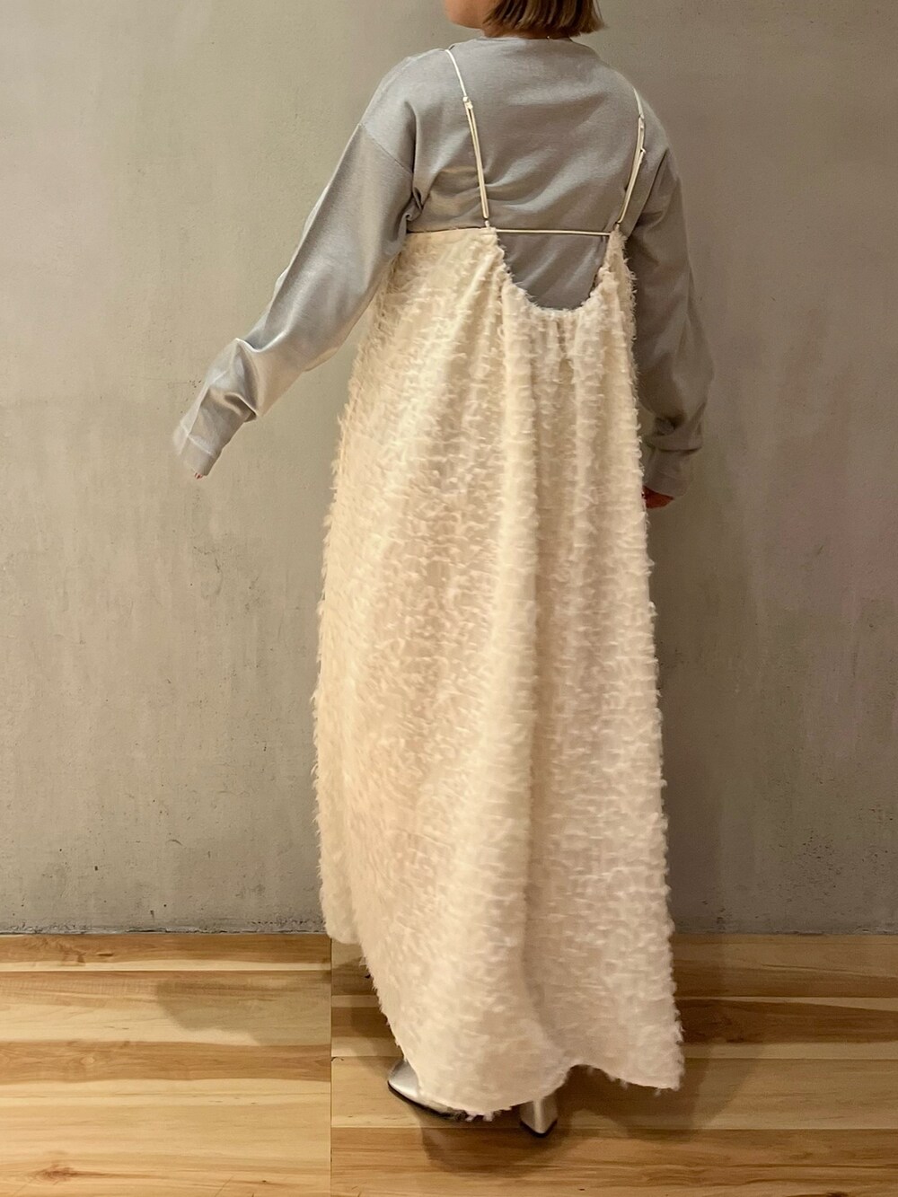 ホワイト系のワンピース、シルバー系のパンプス、シルバー系のニット/セーターを着用したレディースの冬コーディネートの2枚目の写真