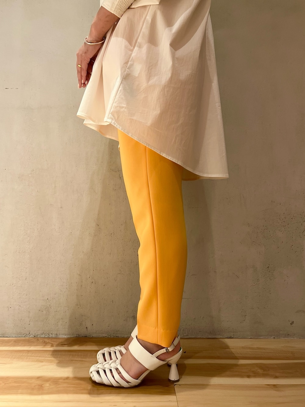 ホワイト系のシャツ/ブラウス、オレンジ系のその他パンツ、ホワイト系のサンダルを着用したレディースの冬コーディネートの7枚目の写真