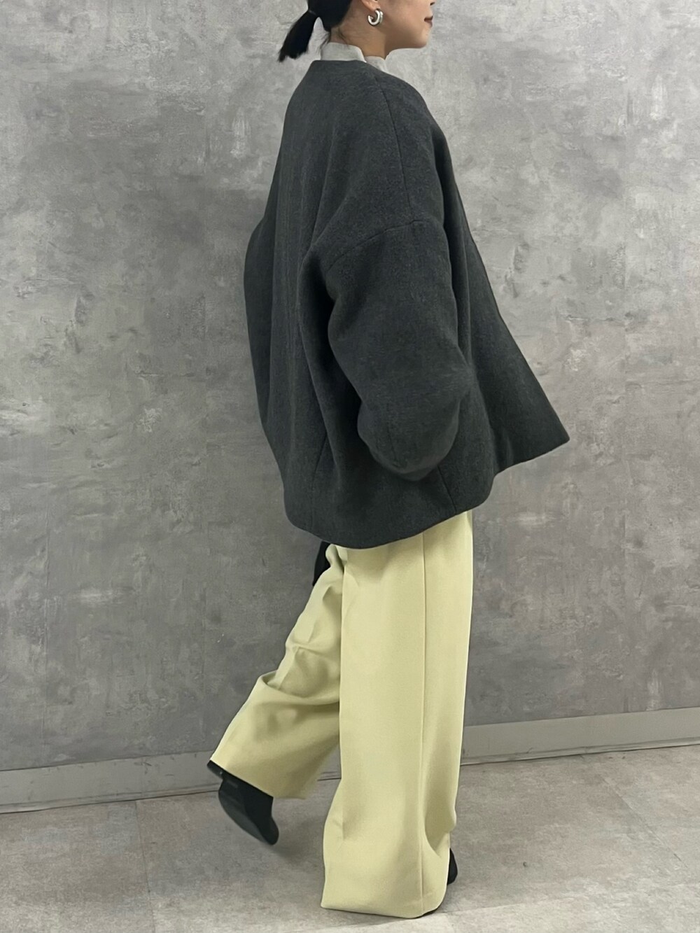 グレー系のノーカラージャケット、グレー系のニット/セーター、イエロー系のその他パンツを着用したレディースの秋コーディネートの3枚目の写真