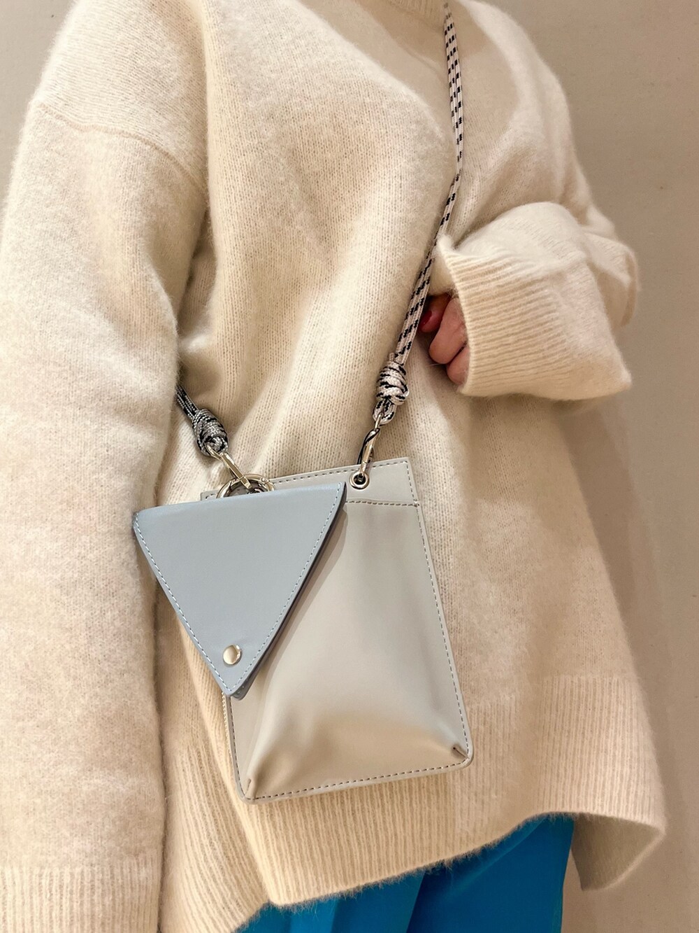 ブラック系のブーツ、ブラック系のTシャツ/カットソー、ホワイト系のニット/セーターを着用したレディースの冬コーディネートの8枚目の写真