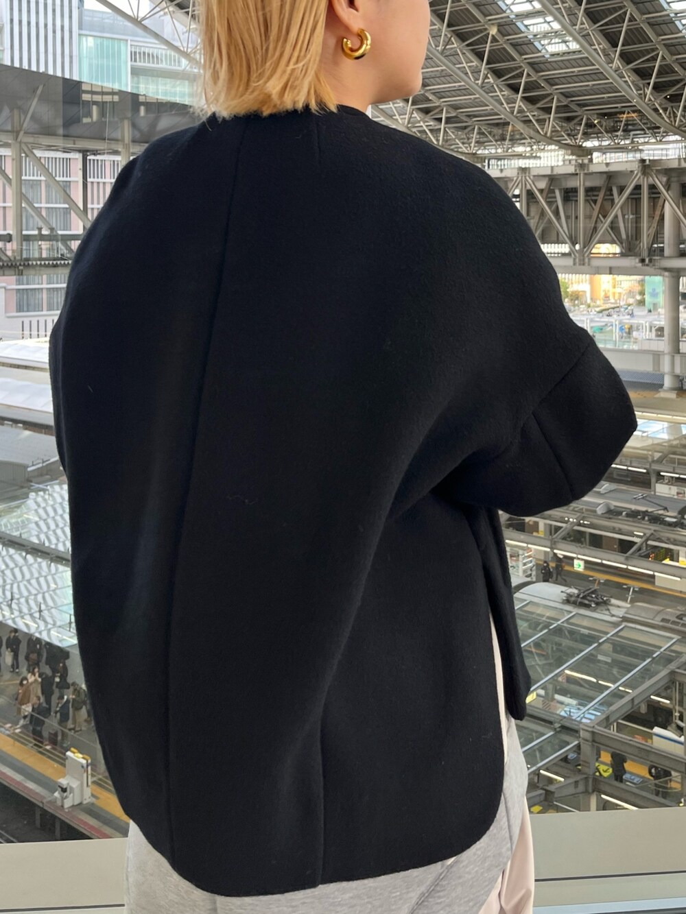 ブラック系のノーカラージャケット、グレー系のワンピース、ブラック系のハンドバッグを着用したレディースの冬コーディネートの6枚目の写真