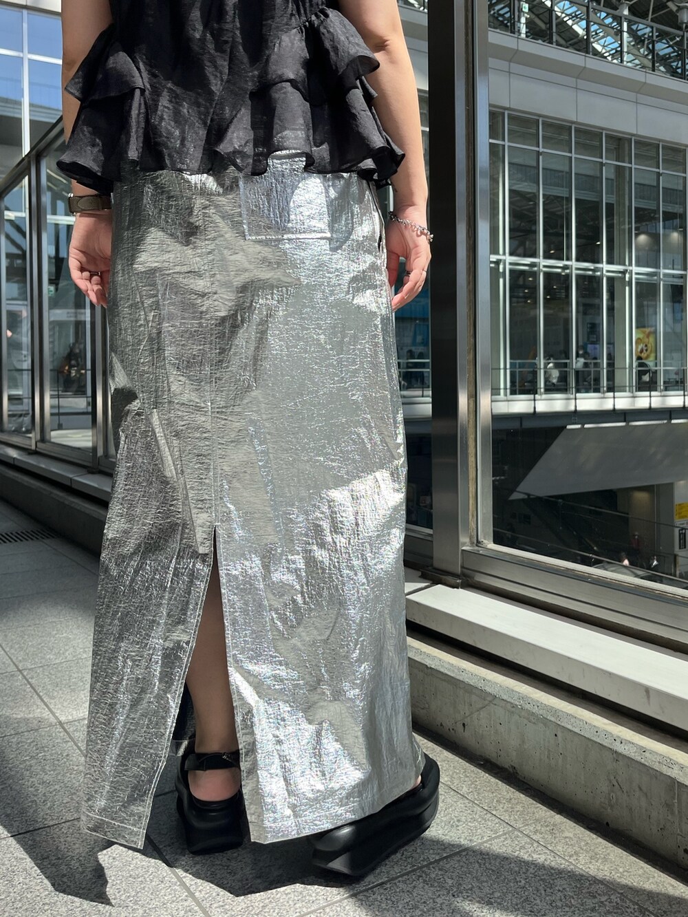 ブラック系のシャツ/ブラウス、シルバー系のスカート、ブラック系のサンダルを着用したレディースの春コーディネートの9枚目の写真