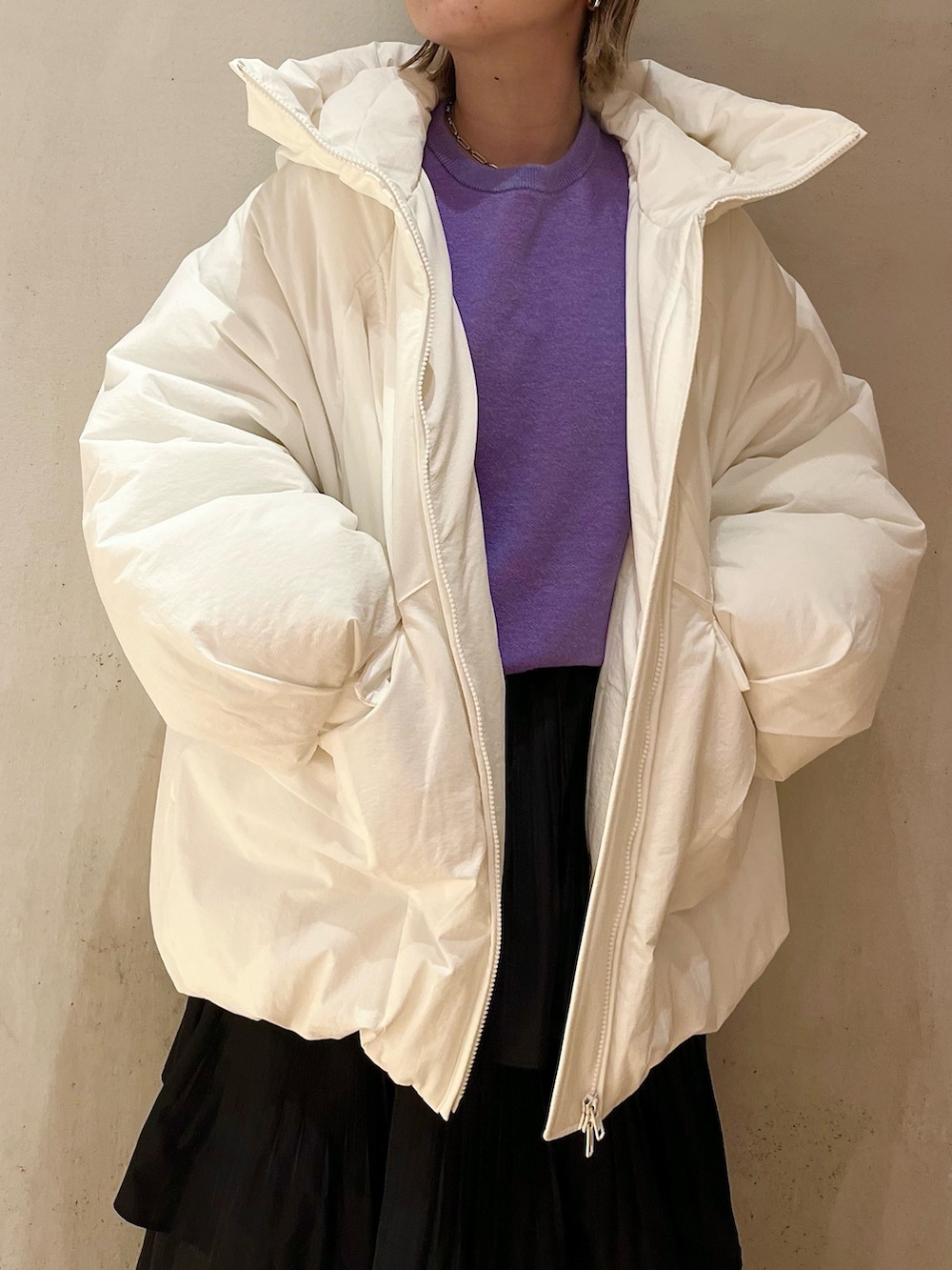 ホワイト系のダウンジャケット/コート、パープル系のニット/セーター、ブラック系のスカートを着用したレディースの夏コーディネートの4枚目の写真