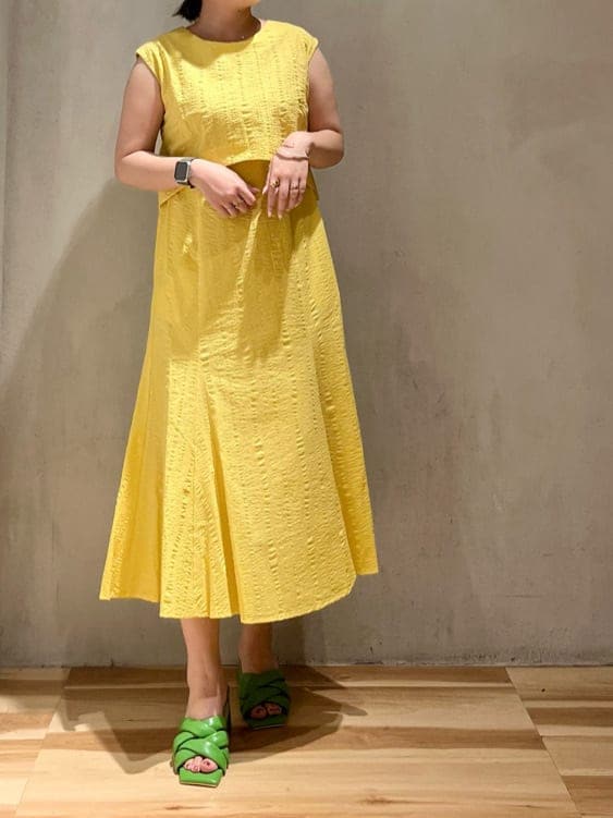 グリーン系のサンダル、イエロー系のワンピースを着用したレディースの夏コーディネートの2枚目の写真