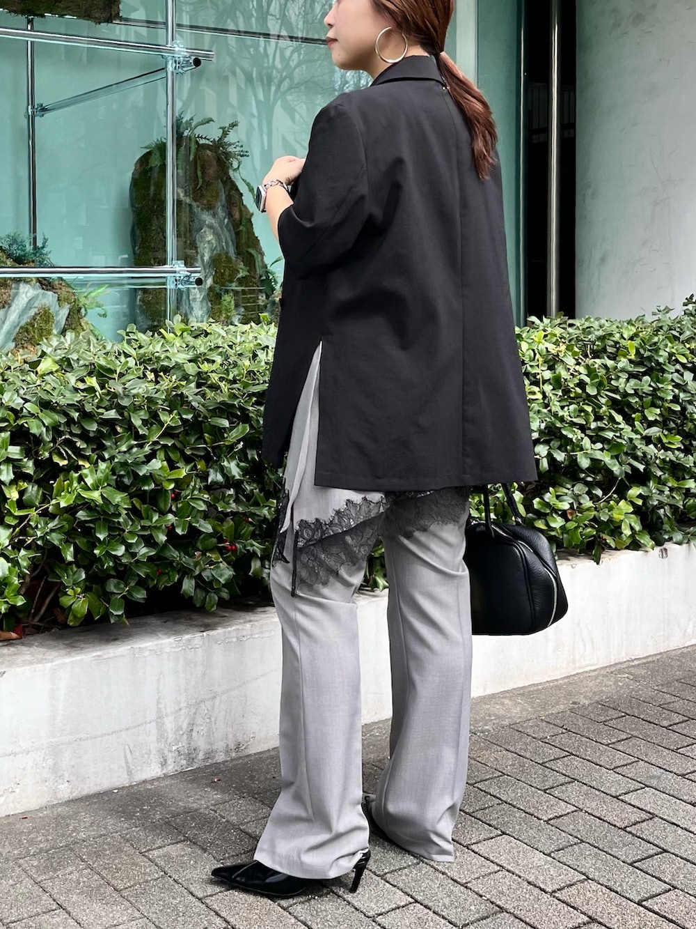 ブラック系のテーラードジャケット、グレー系のその他パンツ、ブラック系のパンプスを着用したレディースの春コーディネートの2枚目の写真