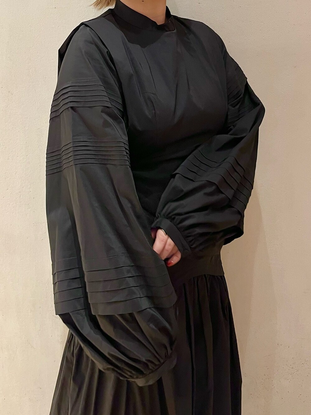 グリーン系のノーカラージャケット、ブラック系のワンピース、ブラック系のブーツを着用したレディースの秋コーディネートの9枚目の写真