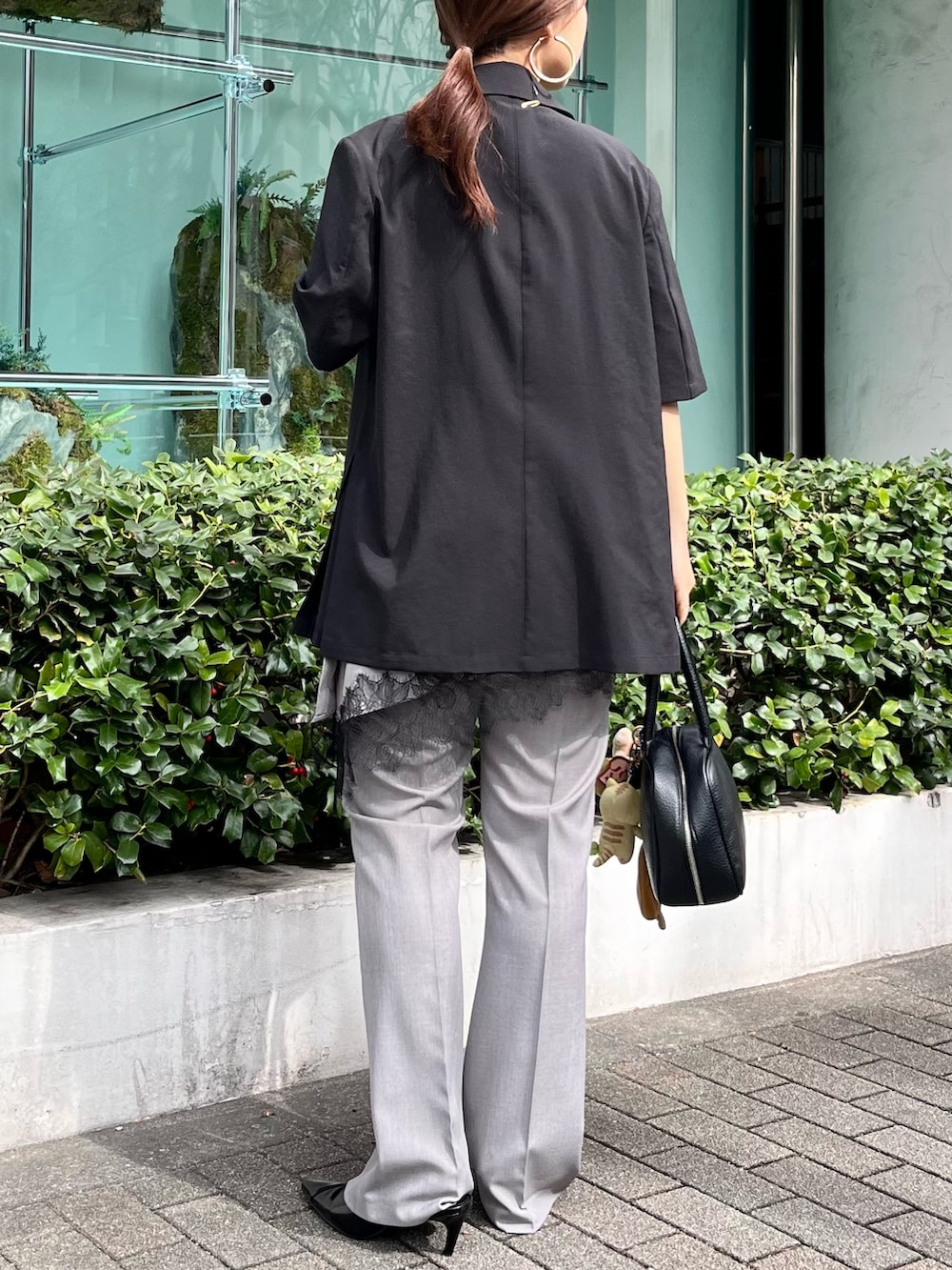 ブラック系のテーラードジャケット、グレー系のその他パンツ、ブラック系のパンプスを着用したレディースの春コーディネートの3枚目の写真