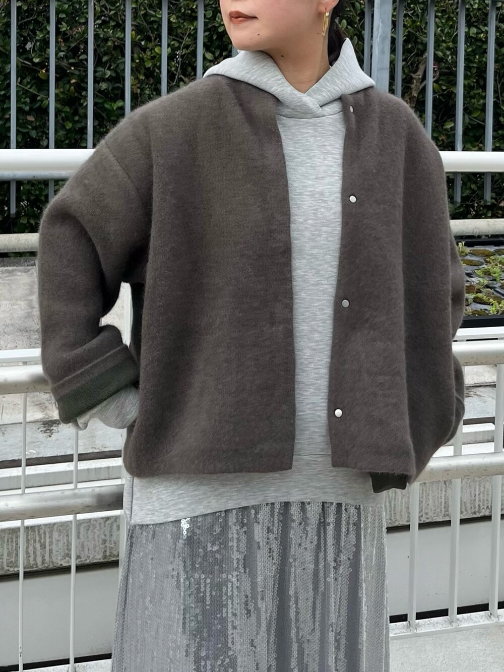 ブラウン系のカーディガン/ボレロ、グレー系のワンピース、ブラック系のブーツを着用したレディースの秋コーディネートの5枚目の写真