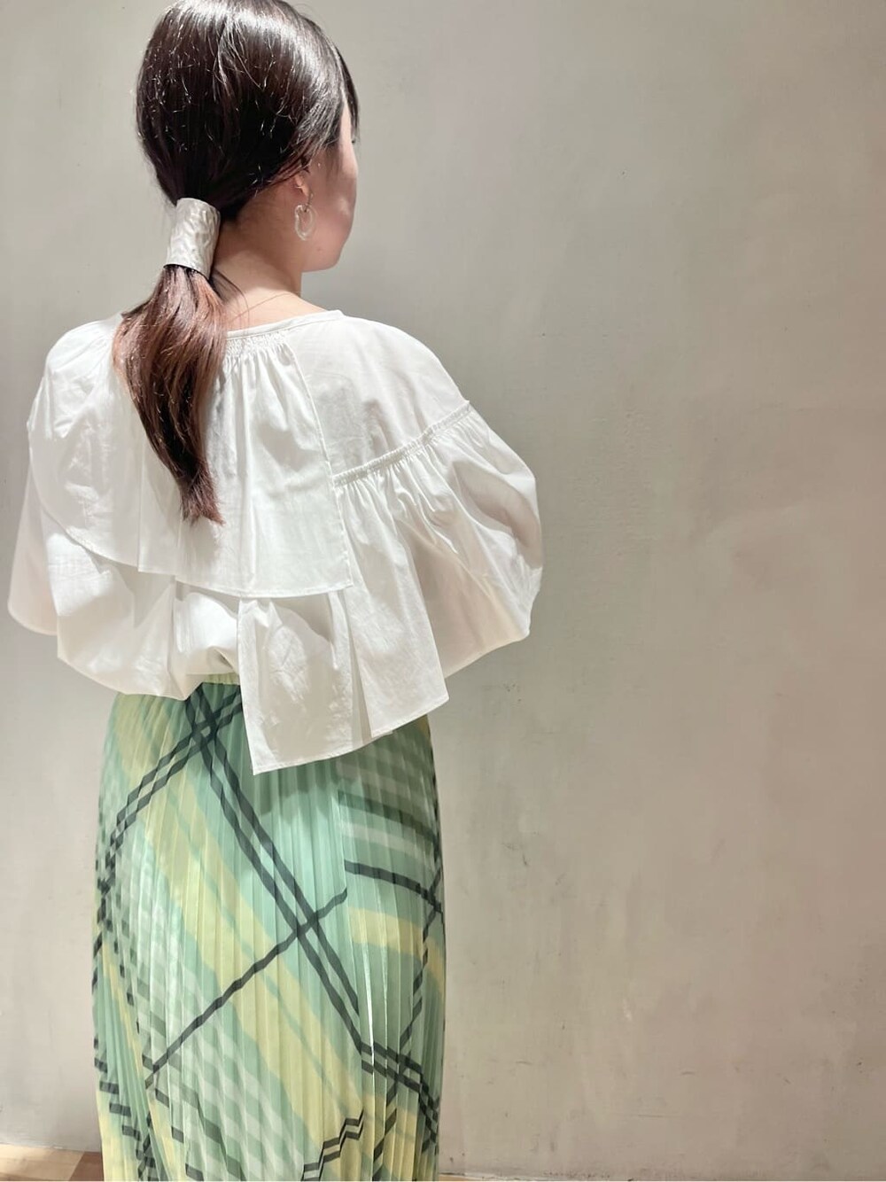 ホワイト系のシャツ/ブラウス、イエロー系のサンダル、グリーン系のスカートを着用したレディースの春コーディネートの4枚目の写真