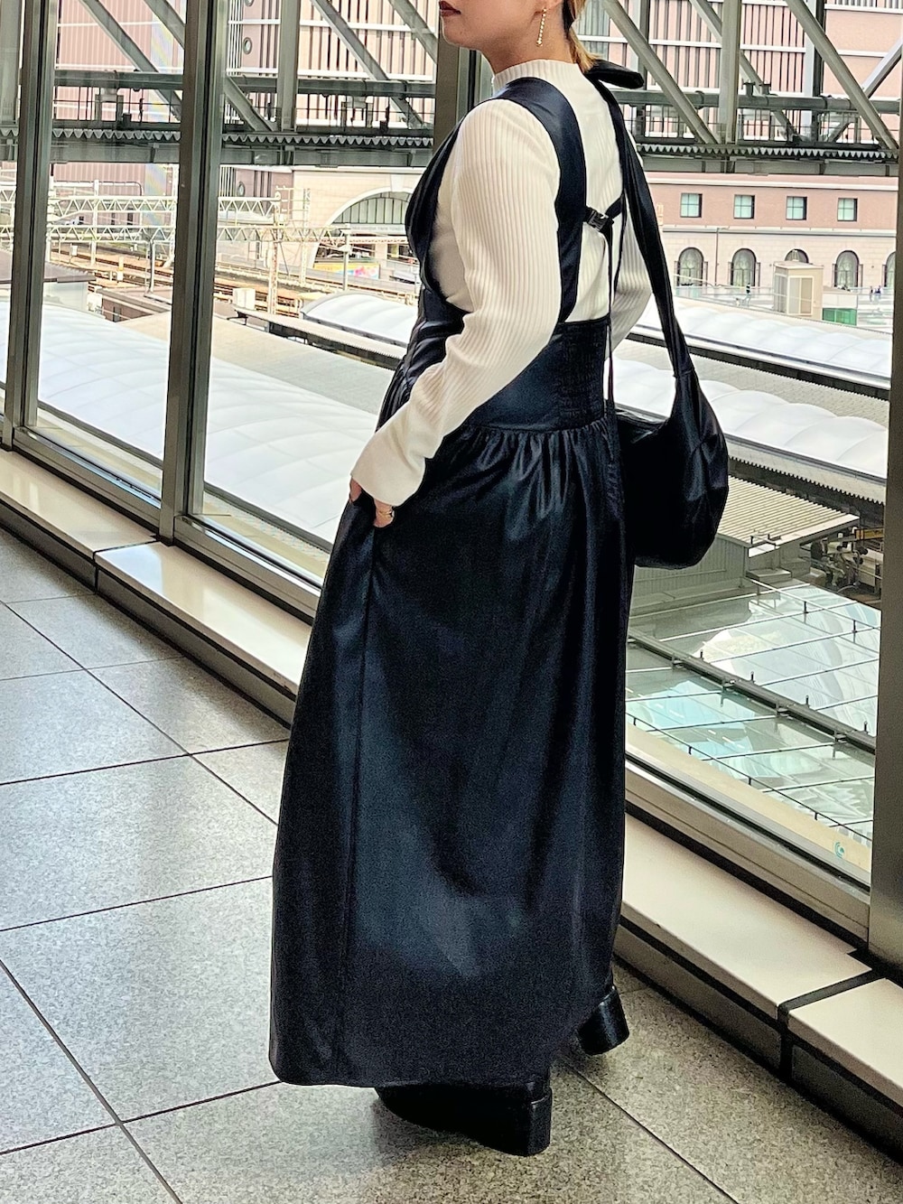 グレー系のノーカラージャケット、ブラック系のジャンパースカート、ホワイト系のニット/セーターを着用したレディースの秋コーディネートの7枚目の写真