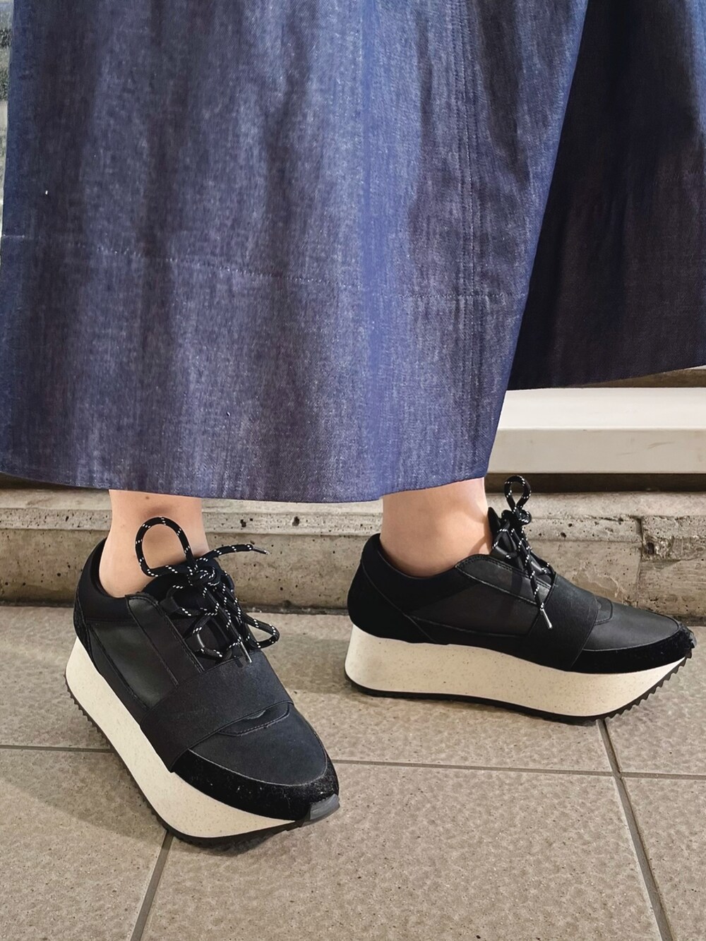 グリーン系のブルゾン、ブルー系のワンピース、ブラック系のスニーカーを着用したレディースの春コーディネートの7枚目の写真